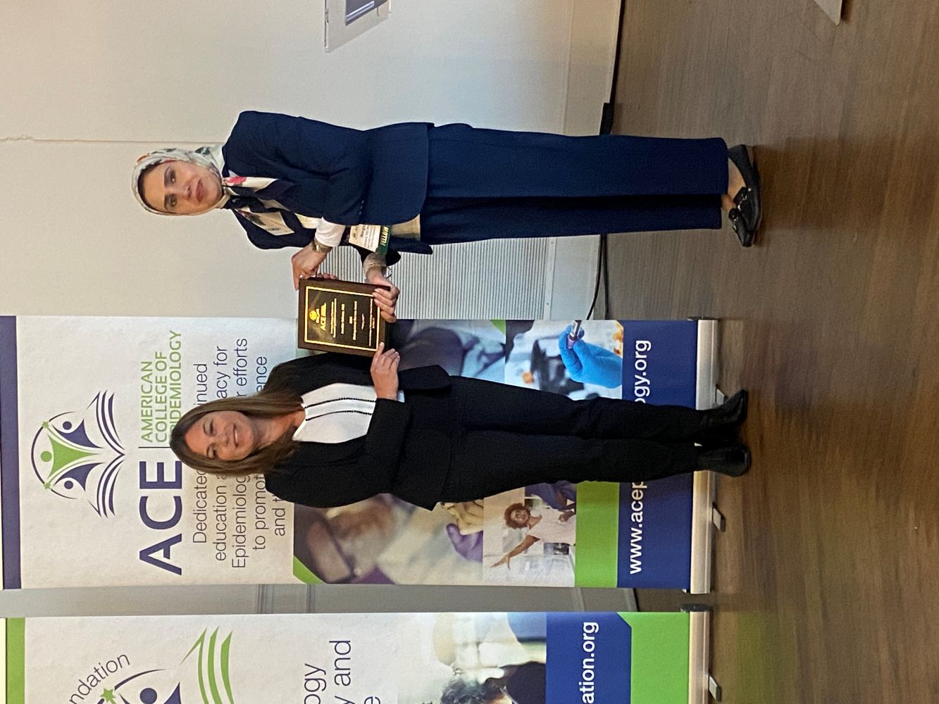 The Distinguished Service Award recipient smiles while receiving her plaque